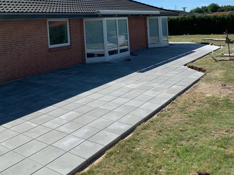 Det færdige resultat efter anlægning af terrasse - en flot terrasse med grå fliser.